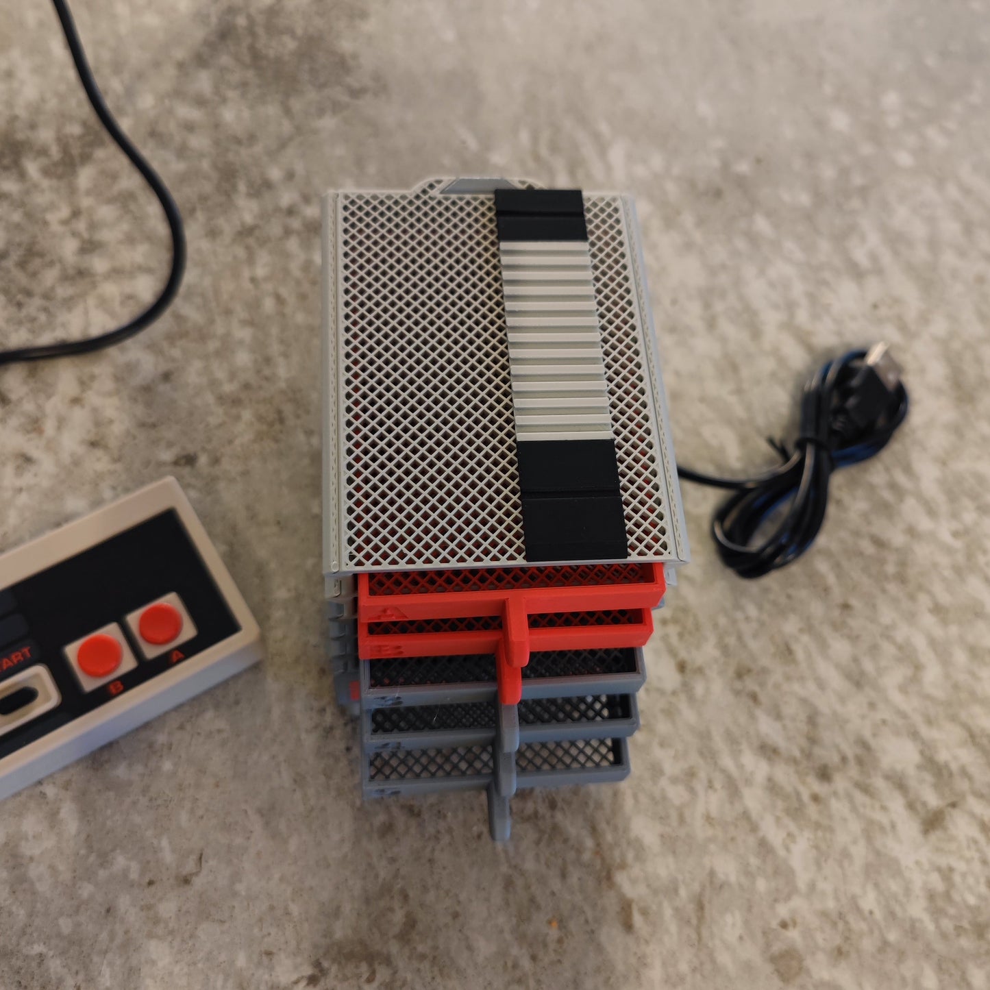 The Seed Dryer - Classic Console by PepperMerchant.net features mesh boards, plastic dividers, and a striped top, styled alongside a retro NES controller and black wire—blending vintage appeal with modern seed-saving innovation.
