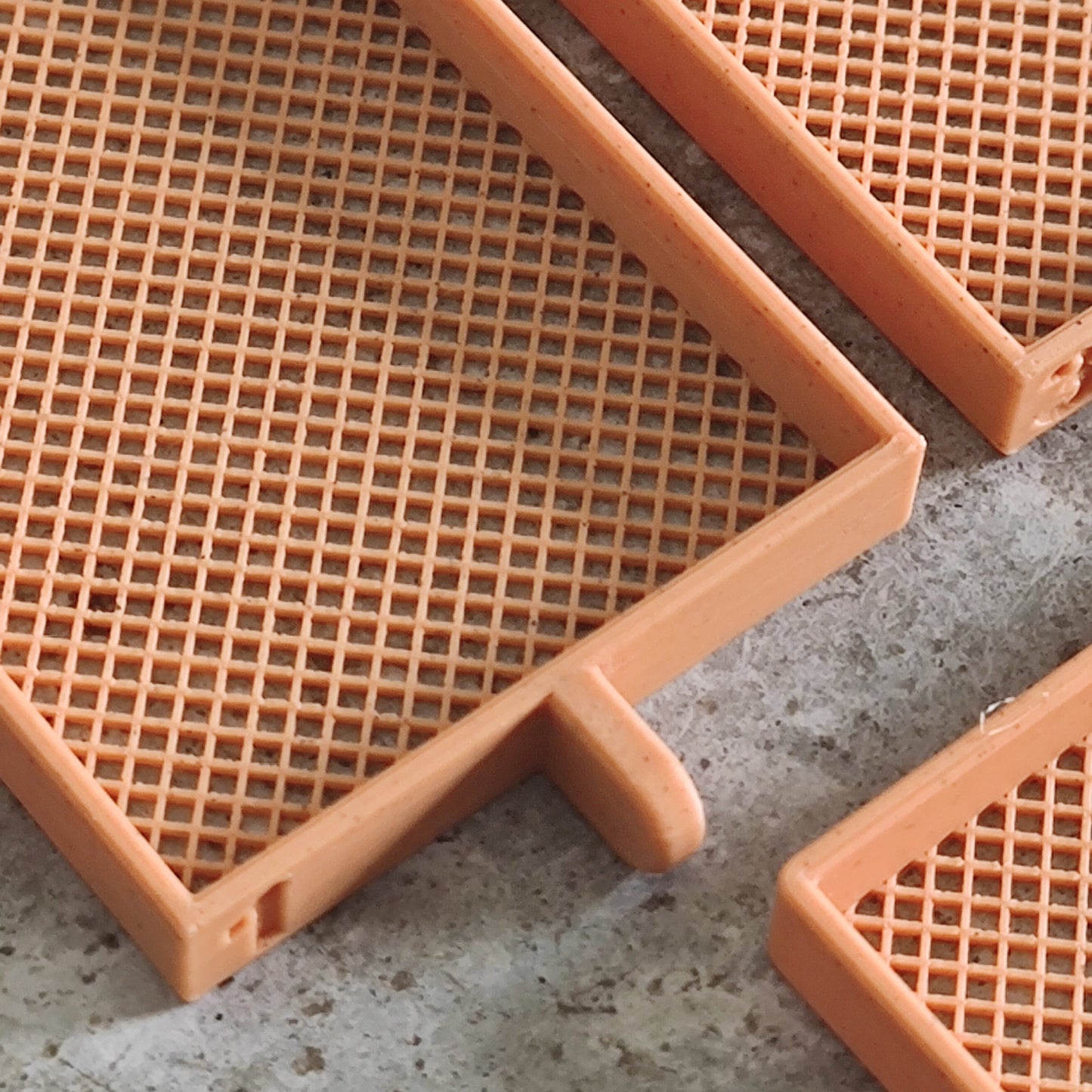 Three orange, rectangular plastic Seed Dryer trays by PepperMerchant.net (Pumpkin Spicy *Limited Edition*) are displayed on a gray, textured surface. Designed with a grid pattern and small tabs along the edges for easy handling or interlocking, these trays are perfect for drying pumpkin spice seeds or for any dedicated seed saver.