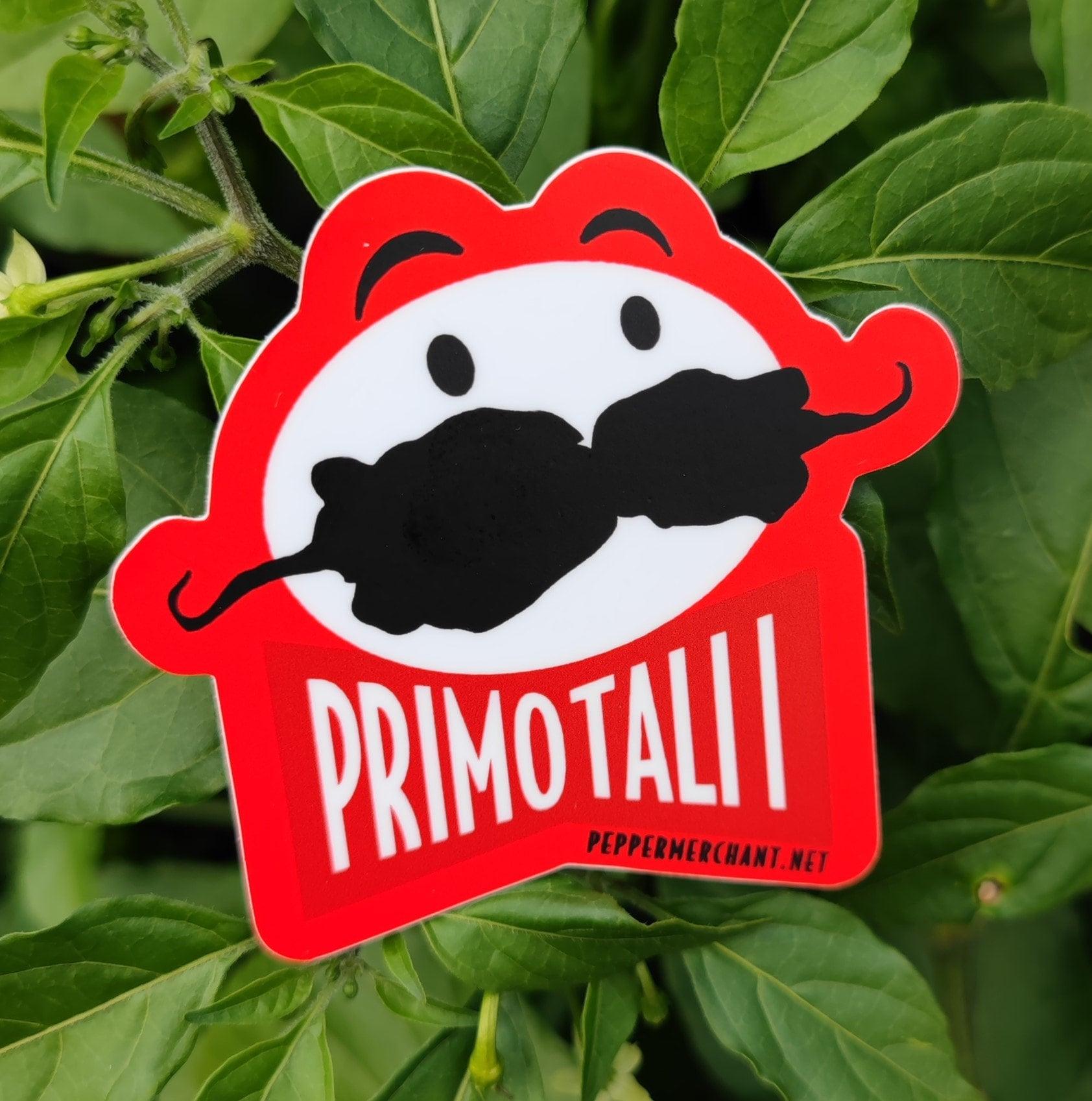 The Primotalii Sticker from PepperMerchant.net showcases a vibrant red design featuring a stylized face with two black peppers forming the mustache. "PRIMOTALI" is prominently displayed below in white text, all set against a lush backdrop of green leaves. The URL "peppermerchant.net" is also included at the bottom. Ideal for those who can't get enough of PM seeds and crave these addictive snacks!